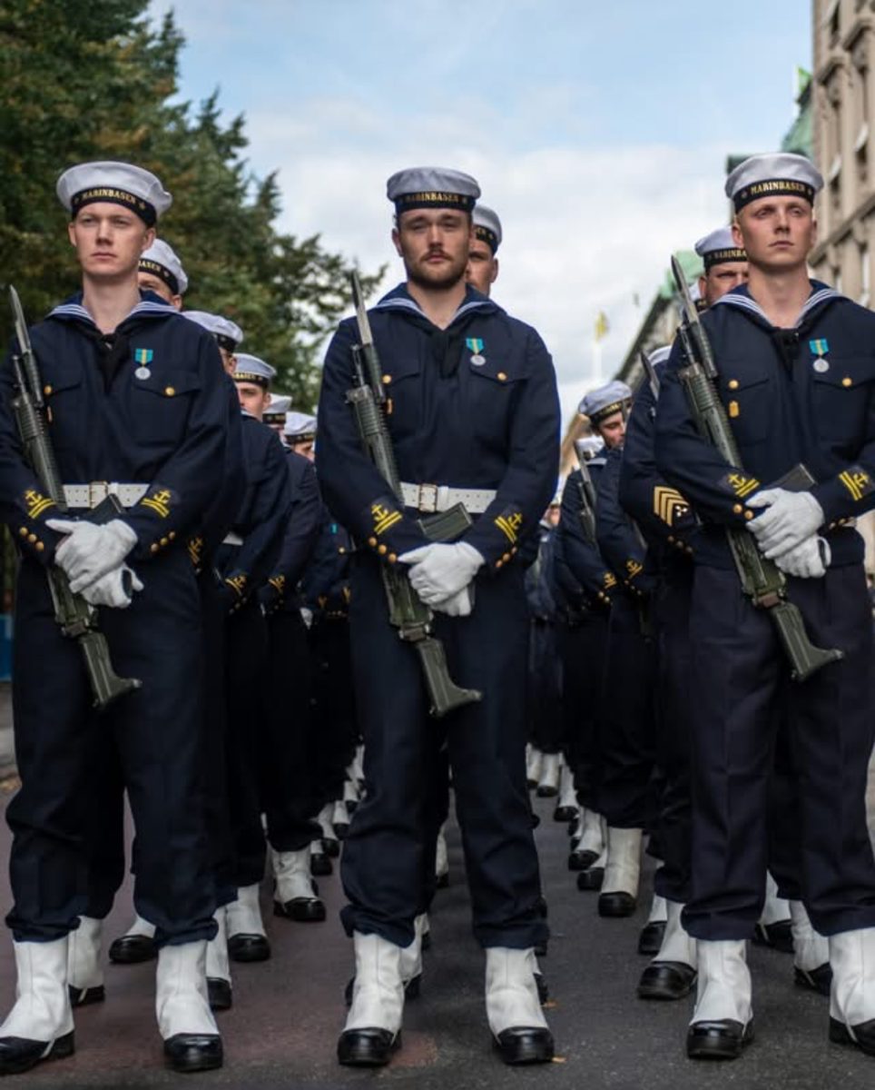 Flottan i led: Meniga i bussarong m/48 med blåkrage och rundmössa. Vit paradlivrem, damasker, vita handskar och Ak 4 med bajonett.