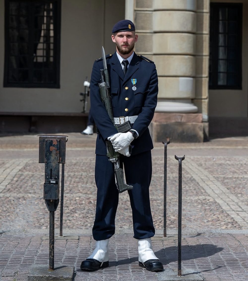 Marinen på högvakt: Vapenrock m/87 blå med slips, mörkblå basker, vit paradlivrem, damasker, vita handskar och Ak 4 med bajonett.